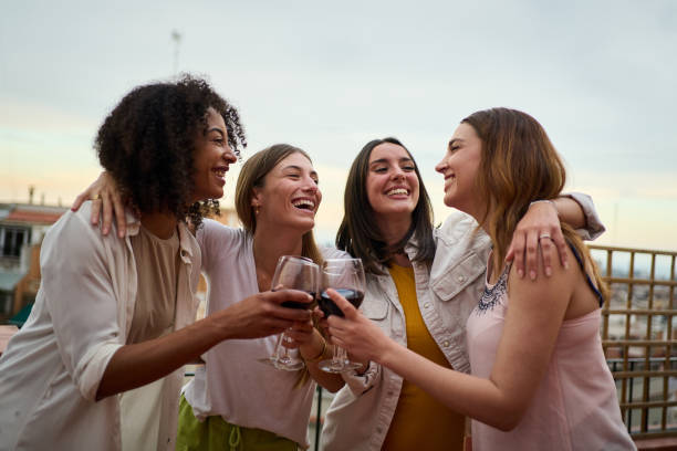 Women friends toasting wine glasses outdoors at a winery