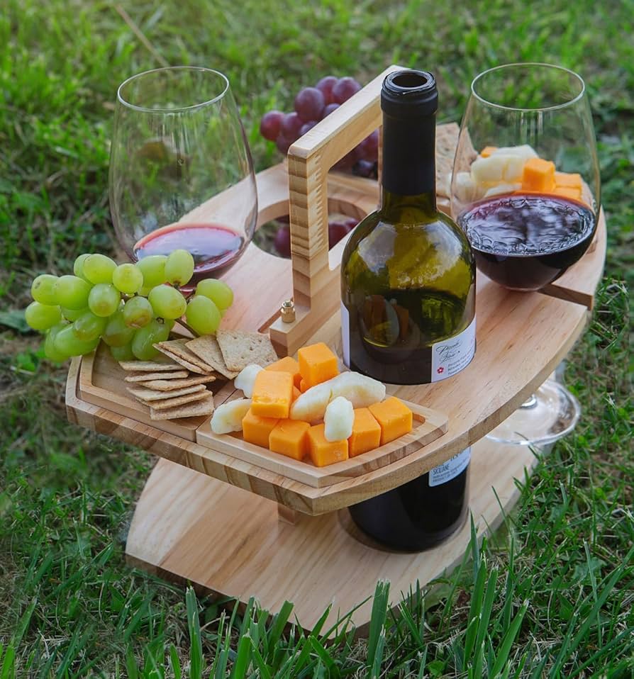 Charcuterie board with wine bottle and glasses outdoors at a winery