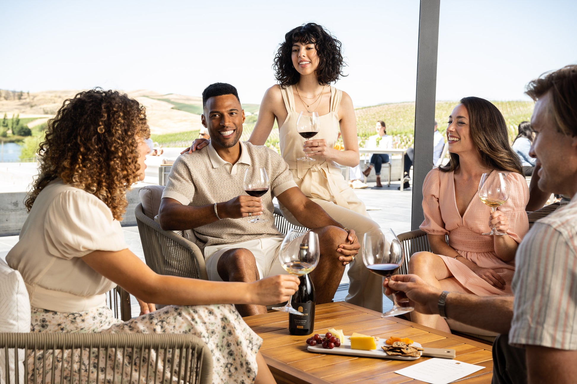 Group of friends enjoying an outdoor wine tasting at a winery